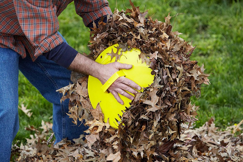 recoger hojas de otoño en el jardín con palas de mano