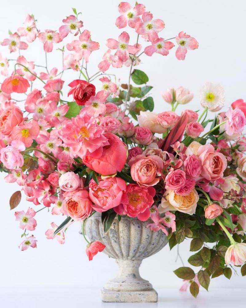 jarrón de piedra y flores de color rosa