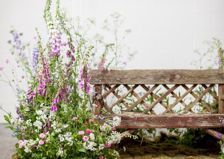 Banco de madera rustico y flores con aire silvestre
