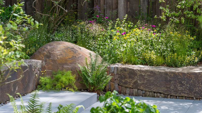 jardin con muro de piedra seca y plantas