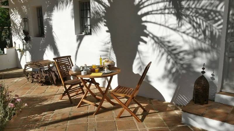 mesa con desayuno en patio de antiguo cortijo en Córdoba