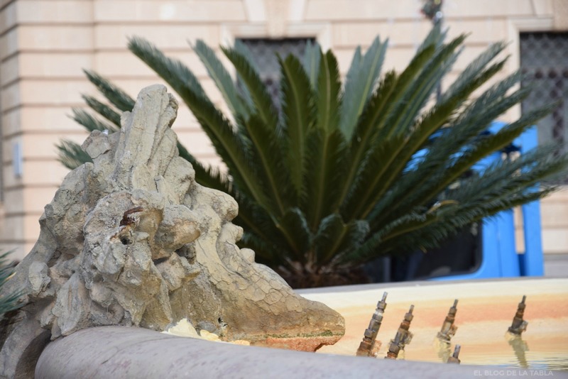 Escultura de piedra y palmera en plaza de Sicilia