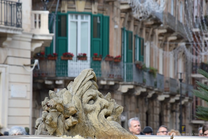 Estatua y al fondo balcones de Siracusa en Sicilia