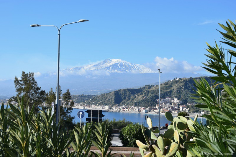 Vista del mar y playa de Giardini con el volcan Etna nevado al fondo