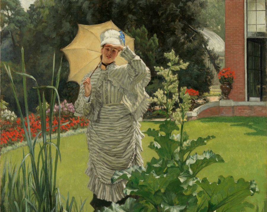 Mujer con sombrilla en un jardín en primavera