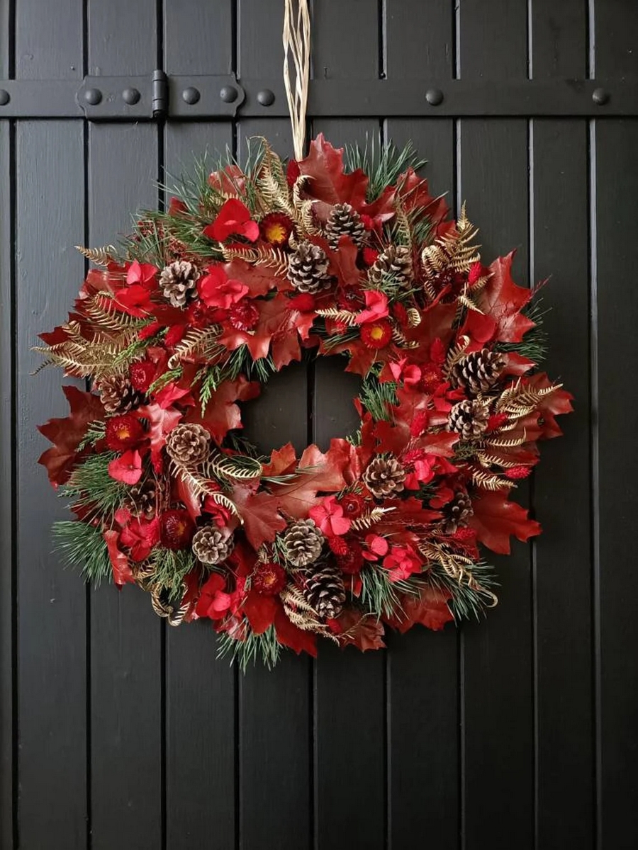 coronas hechas a mano con flores secas y materiales naturales en tonos rojos para Navidad