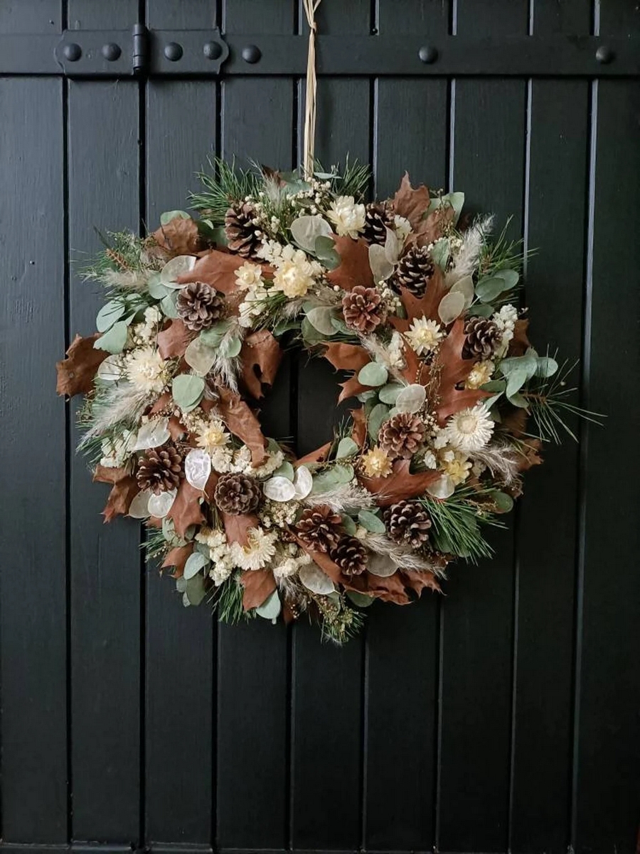 Corona de navidad hecha con flores y follaje seco en tonos beige